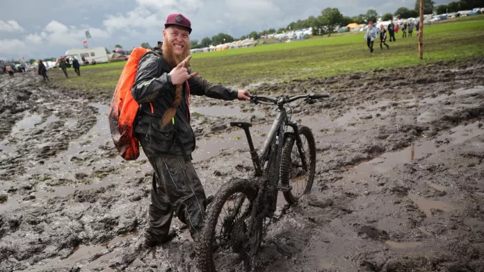 Metal-Fan Lukas Litwin aus Bochum ist mit seinem E-Mountainbike auf dem Festivalgelände unterwegs. Bild: Christian Charisius/dpa (Foto: dpa)