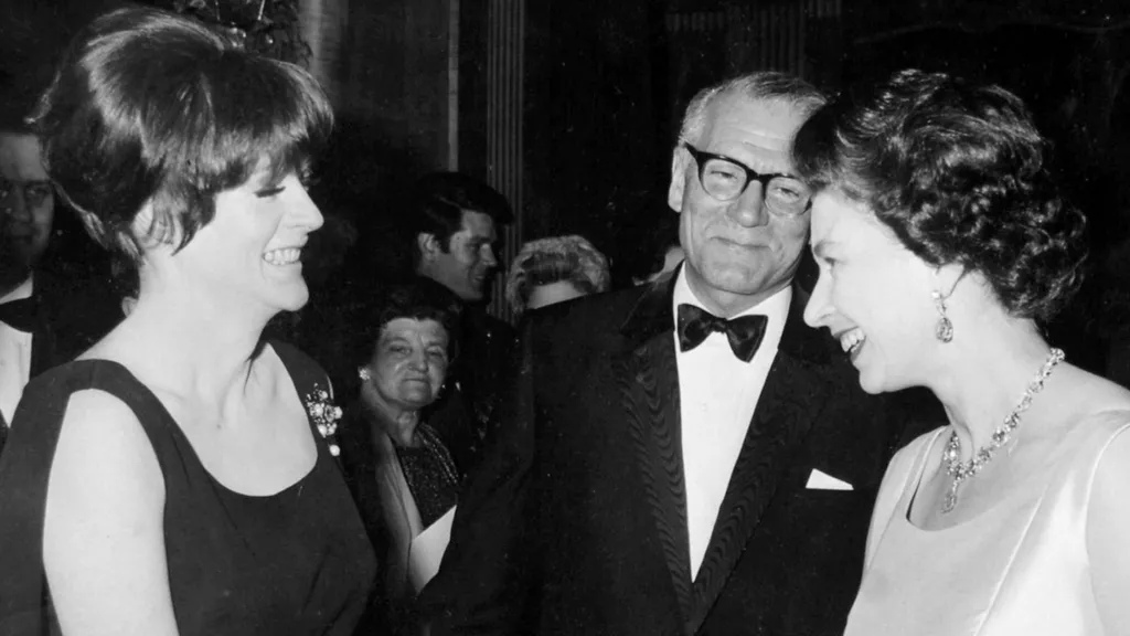 PA Media Königin Elizabeth II. wird Dame Maggie Smith von Sir Laurence Olivier vorgestellt, als die Königin 1966 die Wohltätigkeitspremiere des Films Othello im Odeon Theatre in London besuchte. 